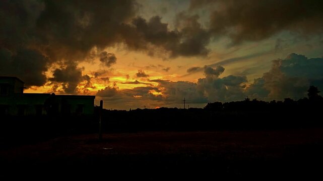 Silhouette of a cricket player playing a shot during dramatic sunset in India. Slow motion sports scene with golden sky, outdoor field, and action moment, ideal for cricket, sports themes.