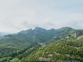 Aerial views of serene Naesosa Temple nestled in the lush green mountains of Buan's Byeonsan Peninsula during early summer in South Korea.