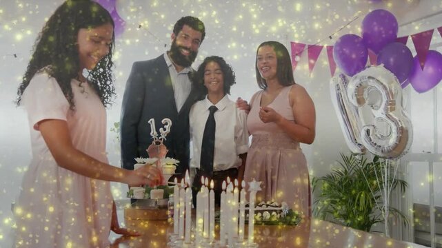 Girl lighting candles with long lighter, family smiling and marking 13th birthday, sparkles overlay