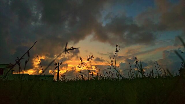 Silhouette of a cricket player playing a shot during dramatic sunset in India. Slow motion sports scene with golden sky, outdoor field, and action moment, ideal for cricket, sports themes.