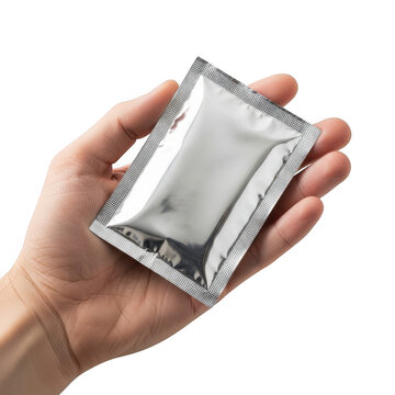 Hand holding a silver foil packet isolated on transparent background