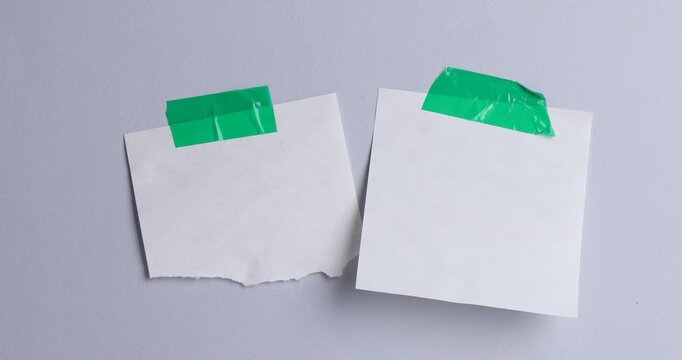 Reminder. Woman putting sticky note onto light grey background, closeup