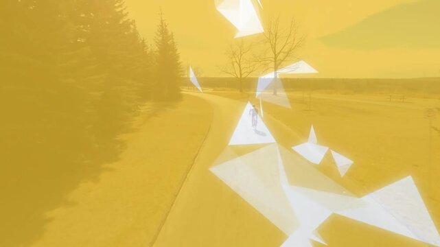 Cyclist riding road; white facets appearing near rider and forming ribbon to signal training