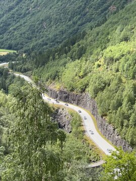 Winding road through forested mountain valley in Stryn, Norway