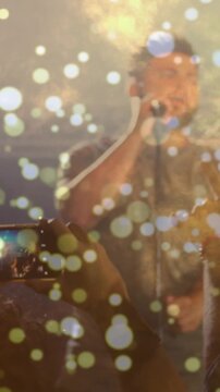 Vertical video: Phone moving forward, concert singer centering and singing into mic for recording