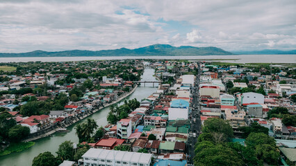 Aerial View of Santa Cruz Laguna Townscape and River, Panoramic Rural Landscape with Laguna de Bay and Mountains at Horizon, Philippines © Gids Stories