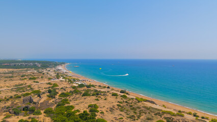 Fototapeta premium Side, Manavgat, Turkey. Panoramic drone flight around ancient peninsula with archaeological ruins, modern city, bays and beaches on Mediterranean coast, summer aerial view