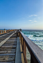 Fototapeta premium Walking the boardwalk, feeling the crisp divine air, and downloading subliminal sky and sea vibes