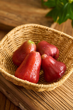 Fresh Wax Apples with Water Drops in a Traditional Bamboo Basket