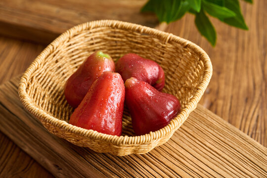 Fresh Wax Apples with Water Drops in a Traditional Bamboo Basket