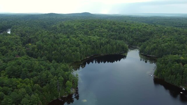 Flying over Buckskin Lake on an overcast, late summer afternoon. Aerial above lakeside cottages along side expansive wilderness of crown land located in the Tory Hill area of Halliburton Highlands.