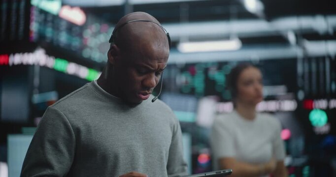Black Male Investment Specialists Monitor Complex Real Time Data on Digital Tablets and Large Screens, While Other Colleagues Use Classic Hand Gestures to Communicate Price and Quantity Across Floor.