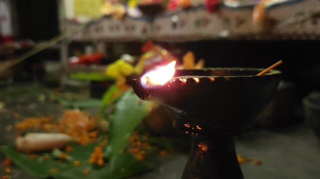 Close-up of burning diya oil lamp glowing in darkness with soft flame. Traditional Indian Diwali lighting symbolizing hope, spirituality, and peace, ideal for festival, religion themes.