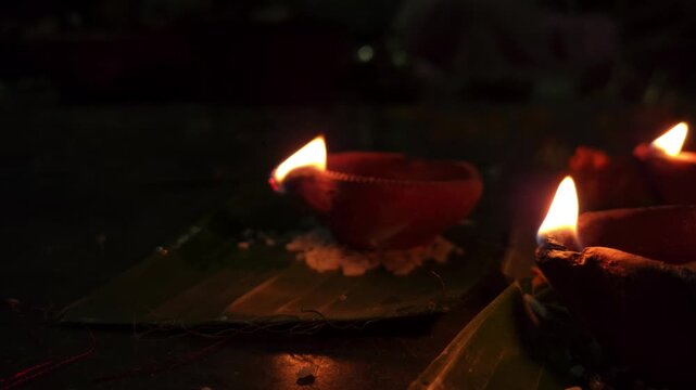 Close-up of burning diya oil lamp glowing in darkness with soft flame. Traditional Indian Diwali lighting symbolizing hope, spirituality, and peace, ideal for festival, religion themes.