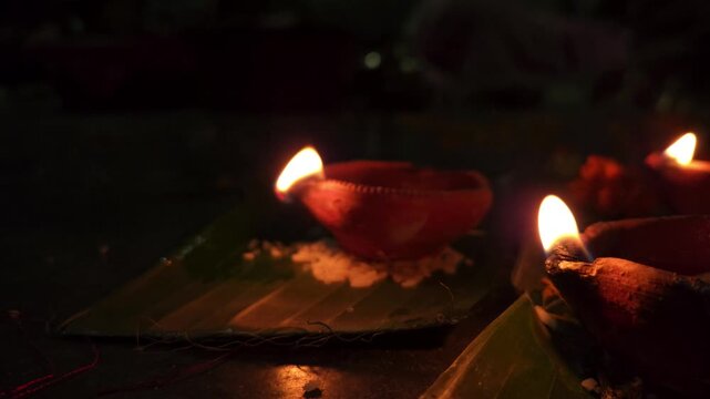 Close-up of burning diya oil lamp glowing in darkness with soft flame. Traditional Indian Diwali lighting symbolizing hope, spirituality, and peace, ideal for festival, religion themes.