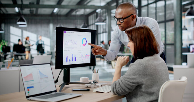 Woman And Man Analyzing Data On Laptops