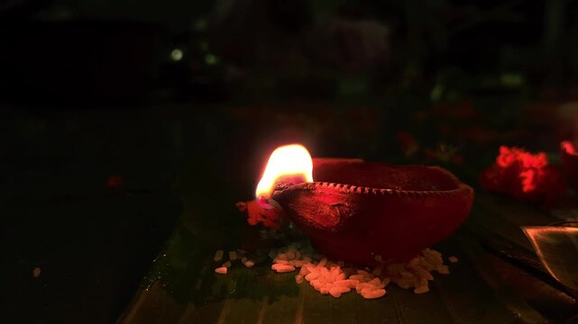 Close-up of burning diya oil lamp glowing in darkness with soft flame. Traditional Indian Diwali lighting symbolizing hope, spirituality, and peace, ideal for festival, religion themes.