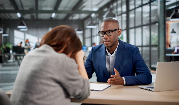 Young Woman Looks Unhappy During A Tough Office Meeting With HR Staff