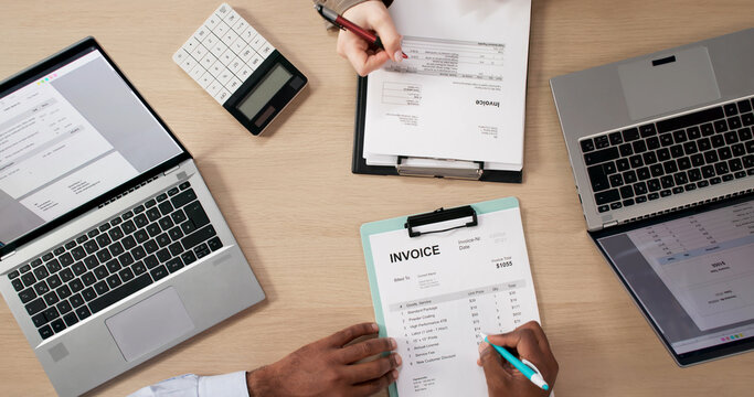 Two Young Professionals In Office Discussing Budget While Using Laptop