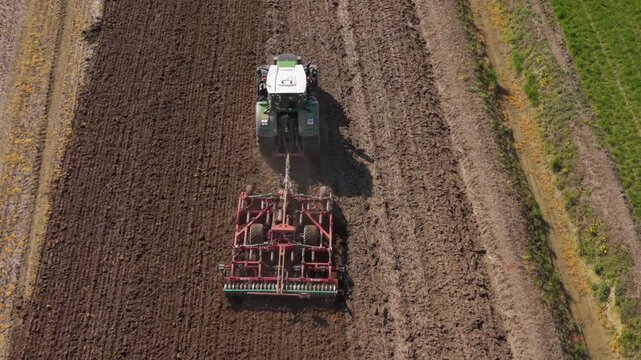 Tractor plowing field: a high-angle shot captures a tractor diligently tilling a vast agricultural field, showcasing the interplay of man and machine in the pursuit of agricultural productivity