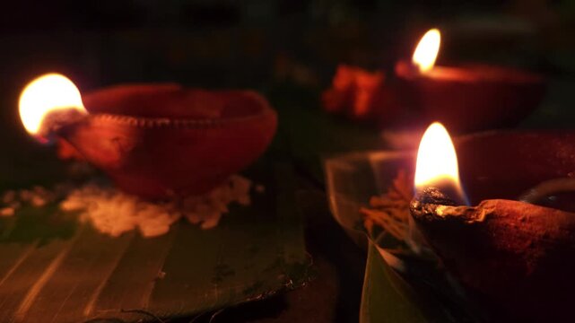 Close-up of burning diya oil lamp glowing in darkness with soft flame. Traditional Indian Diwali lighting symbolizing hope, spirituality, and peace, ideal for festival, religion themes.