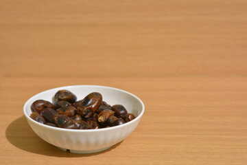 Obraz premium Bowl of dried dates with wide copy space on wooden background