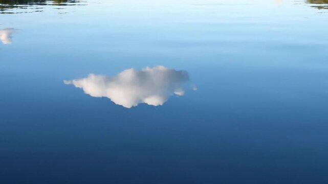 Calm Water Surface Reflecting Sky with Single Cloud Moving Across Serene Lake Setting