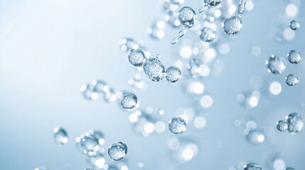 Refreshing clear water drops and bubbles captured in motion against a soft blue background. © David