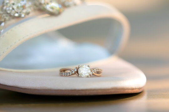 Close up wedding ring on elegant bridal heel.
