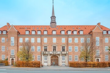 Obraz premium Historic Red Brick Building with Symmetrical Facade and Spire in Copenhagen