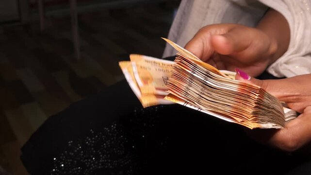 Close up of hands counting Indian rupee notes. Financial transaction concept showing cash handling, savings, economy, income, and money management in India. Ideal for banking and business themes.