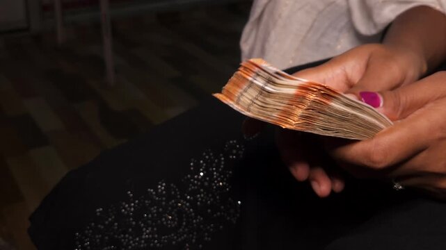 Close up of hands counting Indian rupee notes. Financial transaction concept showing cash handling, savings, economy, income, and money management in India. Ideal for banking and business themes.