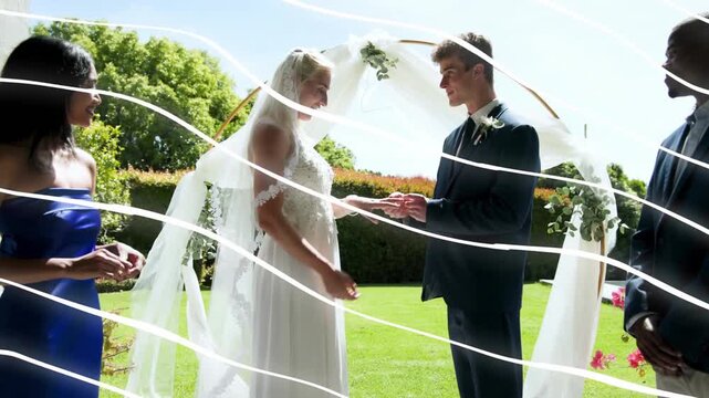 Bride and groom exchanging rings on wooden deck wedding, bridesmaid passing ring, sealing vows