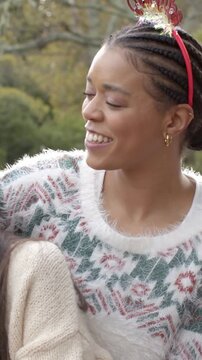 Vertical video: Leaning woman in fuzzy knit after friend cue, aligning for park pose Merry headband