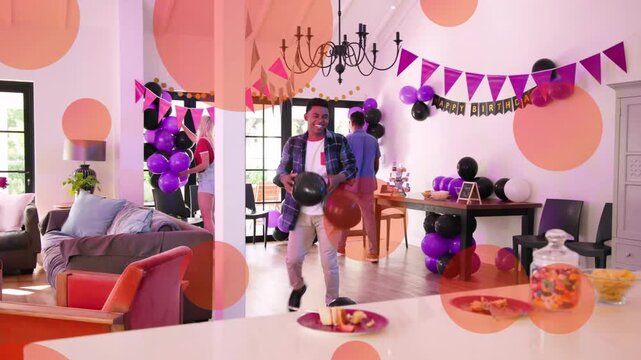 Group of four adults arriving, arranging purple and black balloons in living room for birthday