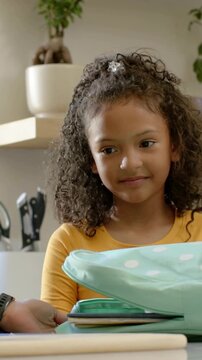 Vertical video: Opening adult packing backpack at home, yellow-top child taking bottle for school