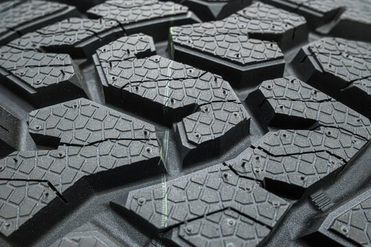 Black tire tread texture background with detailed rubber pattern.
