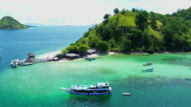 Aerial Low Pass Over Boats at Kelor Island with Green Hills in Background
