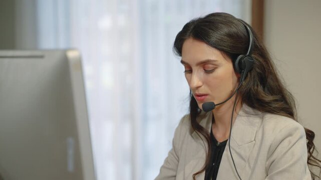 Professional female customer service representative wearing headset assisting clients in office environment
