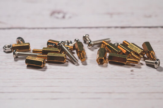 Assorted brass spacers screws and nuts for electronic device mounting.