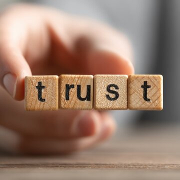 Trust concept with wooden blocks held by hand.