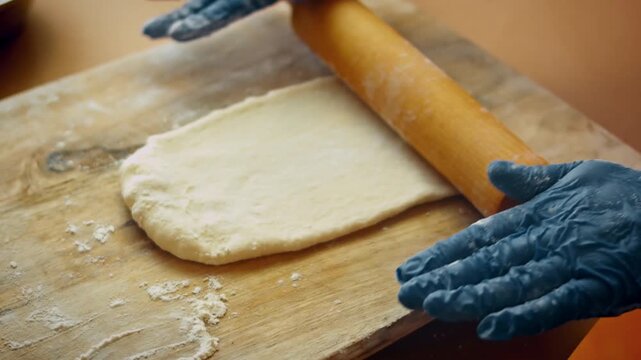 Dough being rolled flat with rolling pin