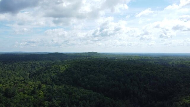 Aerial over the expansive wilderness of crown land located in the Tory Hill area of Haliburton Highlands East, in southern Ontario, Canada. Flying on a shadowy overcast, late summer afternoon.