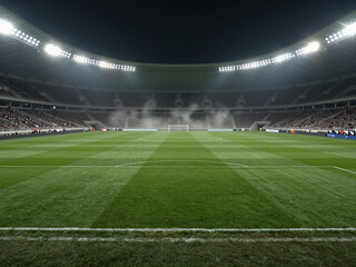 Fototapeta premium Night soccer stadium background with illuminated football field and green grass