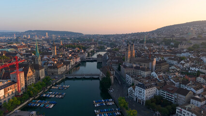 Fototapeta premium Golden cityscape scene. Sunset illuminates historic Zurich with modern and medieval structures