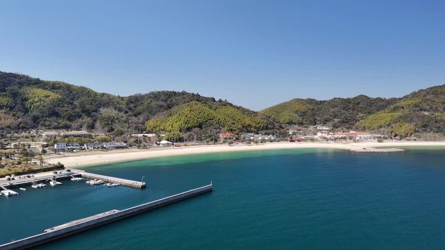 Aerial drone view of emerald green and deep blue ocean with sandy beach in Japan 01 