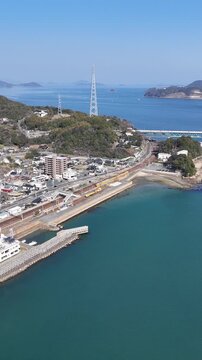 Vertical aerial drone view of cars crossing a bridge over the Seto Inland Sea with ships in Japan 09