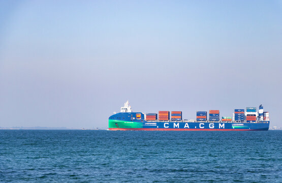 Large LNG powered CMA CGM container ship transporting colorful cargo boxes on the blue sea with a small fishing boat nearby, İzmir Bay, İzmir, Turkey. March 11, 2026.