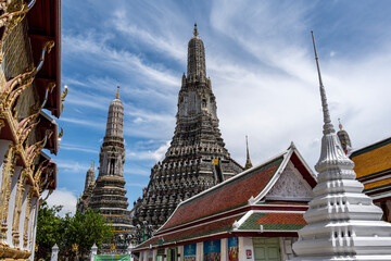Fototapeta premium Thais in traditional costumes relax at the Temple of Dawn in Bangkok on a sunny day.
