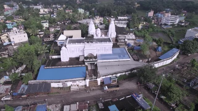 Wide aerial drone shot of Chhatia Bata Jagannath Temple surrounded by greenery in Odisha, India.